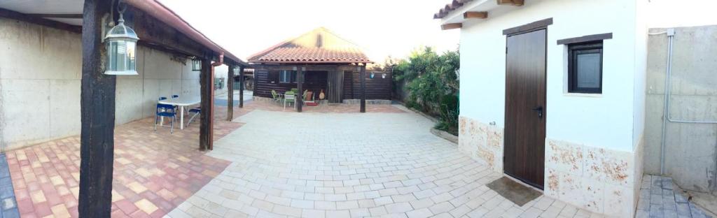 einen Backsteinsteg zwischen zwei Gebäuden mit einem Haus in der Unterkunft La casita in Tarazona de la Mancha