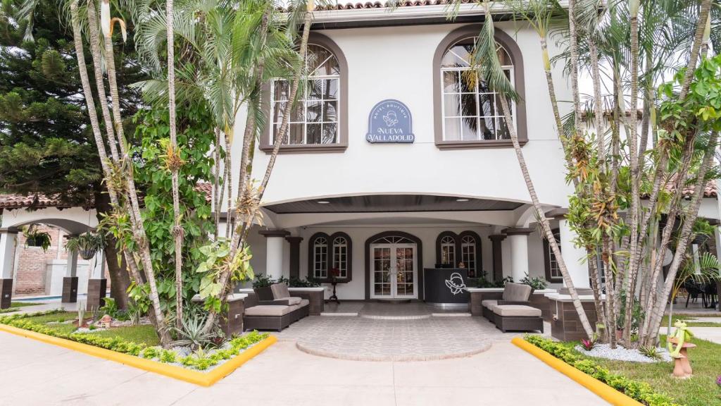 Un edificio con palmeras delante. en Hotel Boutique Nueva Valladolid, en Comayagua