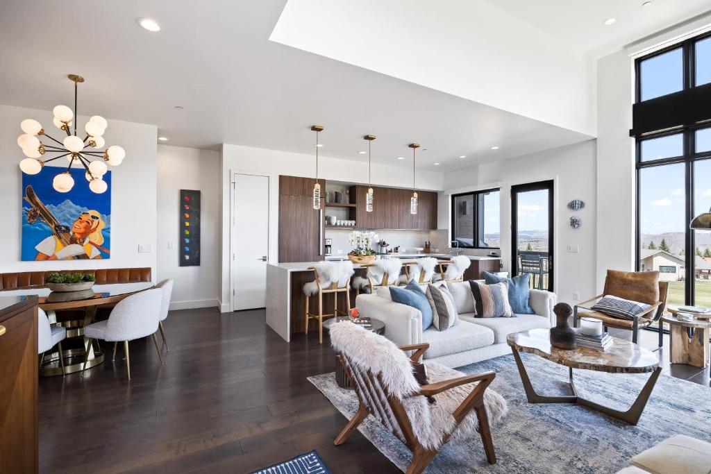 Una sala de estar y una cocina con un sofá y una mesa. en Walk to Gondola, Heated Pool, Luxury Interiors, 2 Car Garage, Sleeps 12, Spacious Patio!, en Park City
