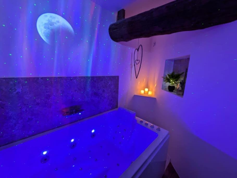Cette chambre violette dispose d'une baignoire avec la lune et les étoiles. dans l'établissement La Galatée, Balnéo et Sauna privatifs, à Saint-Saturnin-lès-Avignon