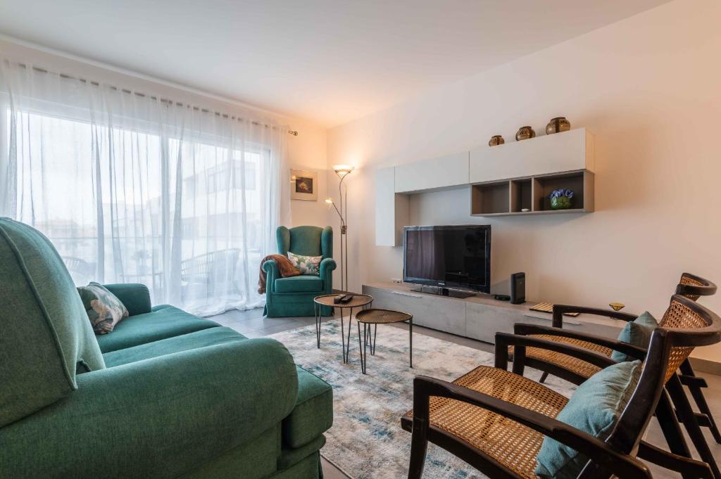 a living room with a couch and chairs and a television at Caravelas 2-Bedroom Apartment with Pool - 50m from the Beach in Armação de Pêra