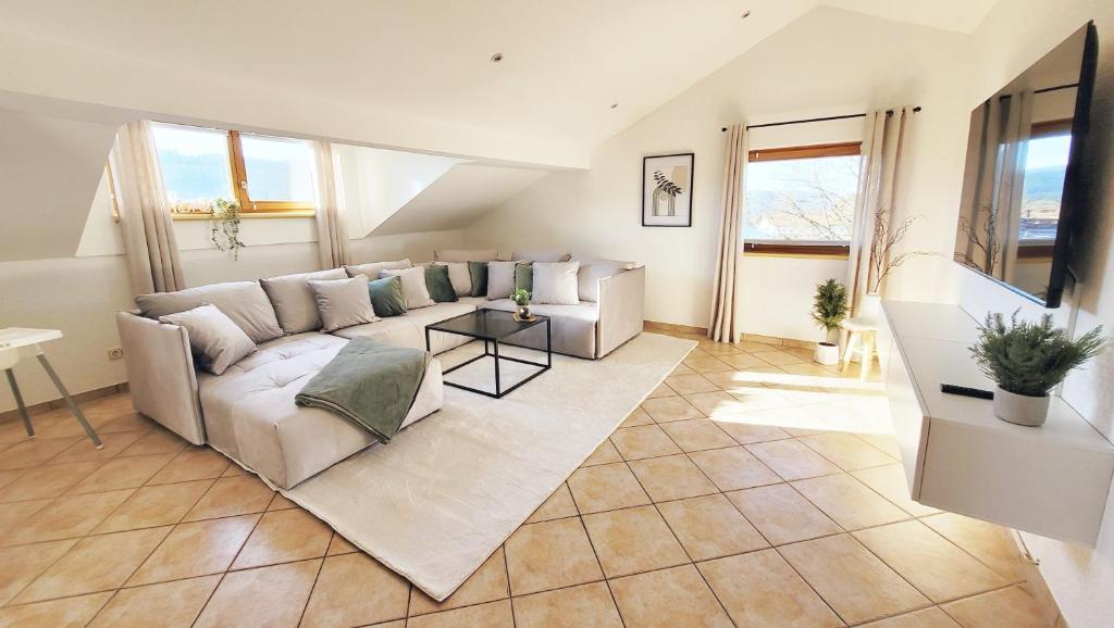 a living room with a couch and a table at Gemütliche Ferienwohnung in Bodenmais I Sauna I Balkon I Blick Silberberg in Bodenmais