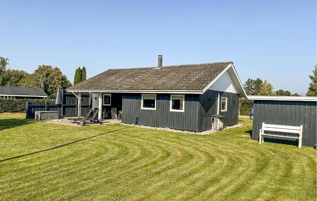 a black house with a field in front of it at 3 Bedroom Lovely Home In Sydals in Neder Lysabild