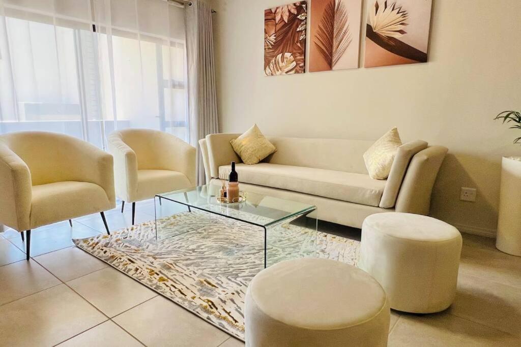 a living room with a couch and a table and chairs at Sunset Haven in Midrand
