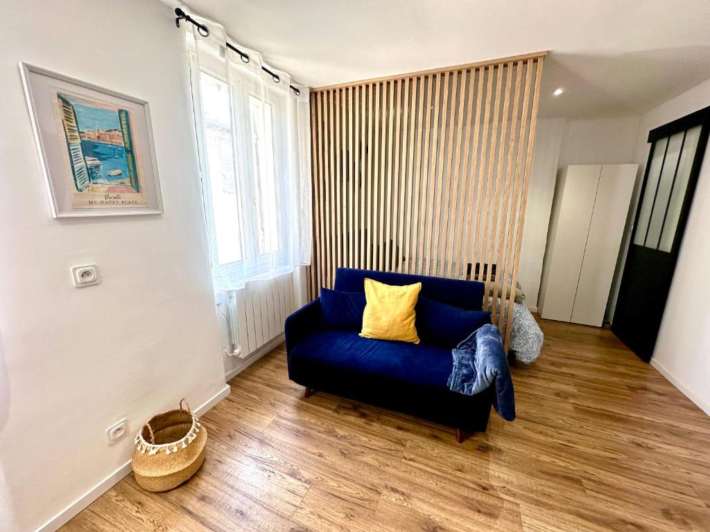 un salon avec un canapé bleu et une fenêtre dans l'établissement Appartement Emplacement Central - Proche Gare, à Marseille