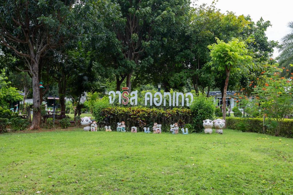 un gruppo di statue in un parco con un cartello di Jaris Cottage a Nong Nam Daeng