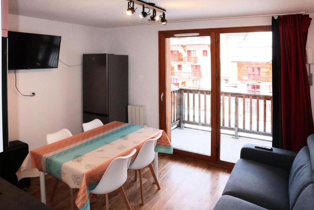 d'un salon avec une table et un balcon. dans l'établissement Les Chalets De Bois Mean - Résidence le Bois Méan 2 pièces pour 6 personnes MAE-6814, aux Orres