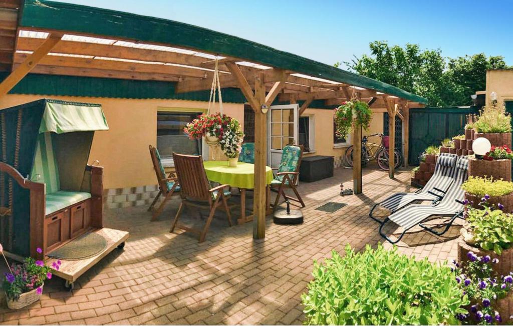 een terras met een tafel en stoelen onder een pergola bij Ferienhaus Zempin Seebad in Zempin