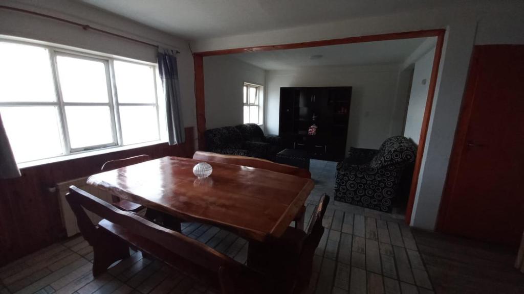 a dining room with a wooden table and chairs at Departamento Amplio Familiar in Ushuaia