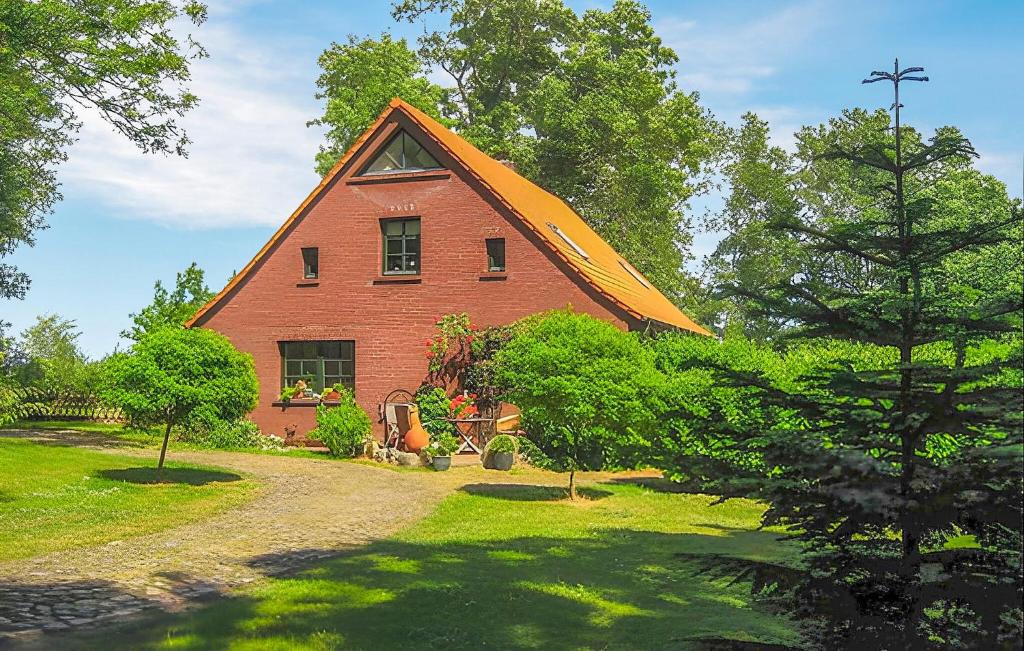 un grande fienile rosso con un grande tetto arancione di Ferienwohnung Altenkirchen a Gudderitz