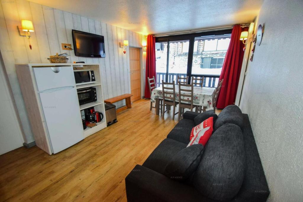 Il comprend un salon avec un canapé, une télévision et une cuisine. dans l'établissement Résidence Le Serro Torre - 3 Pièces 6 pers - LE CERRO TORRE - PLAGNE CENTRE MAE-1111, à La Plagne Tarentaise