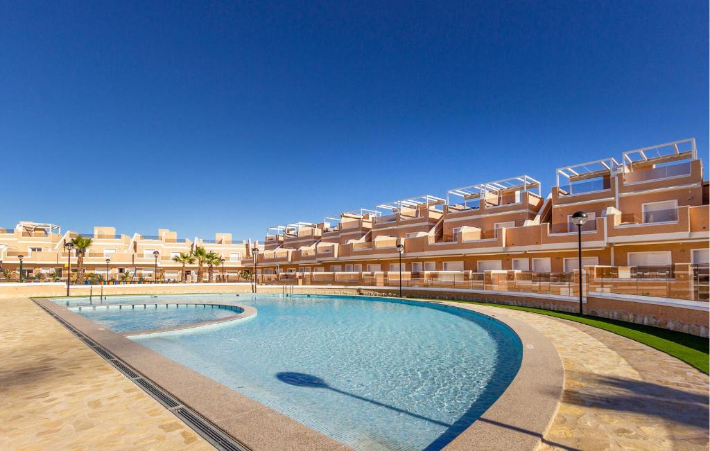 un complejo con piscina frente a un edificio en Cozy Home In Torre De La Horadada, en Torre de la Horadada