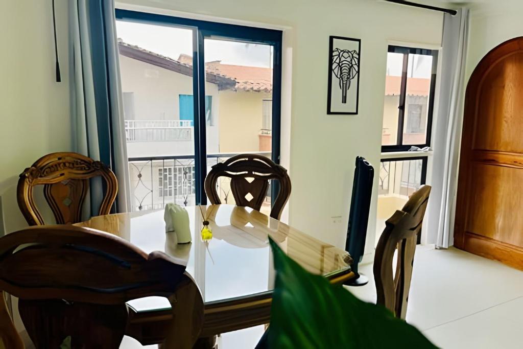 een eetkamer met een tafel en stoelen en een raam bij ApartaEstudio con balcón e iluminado Cerca de todo in Envigado