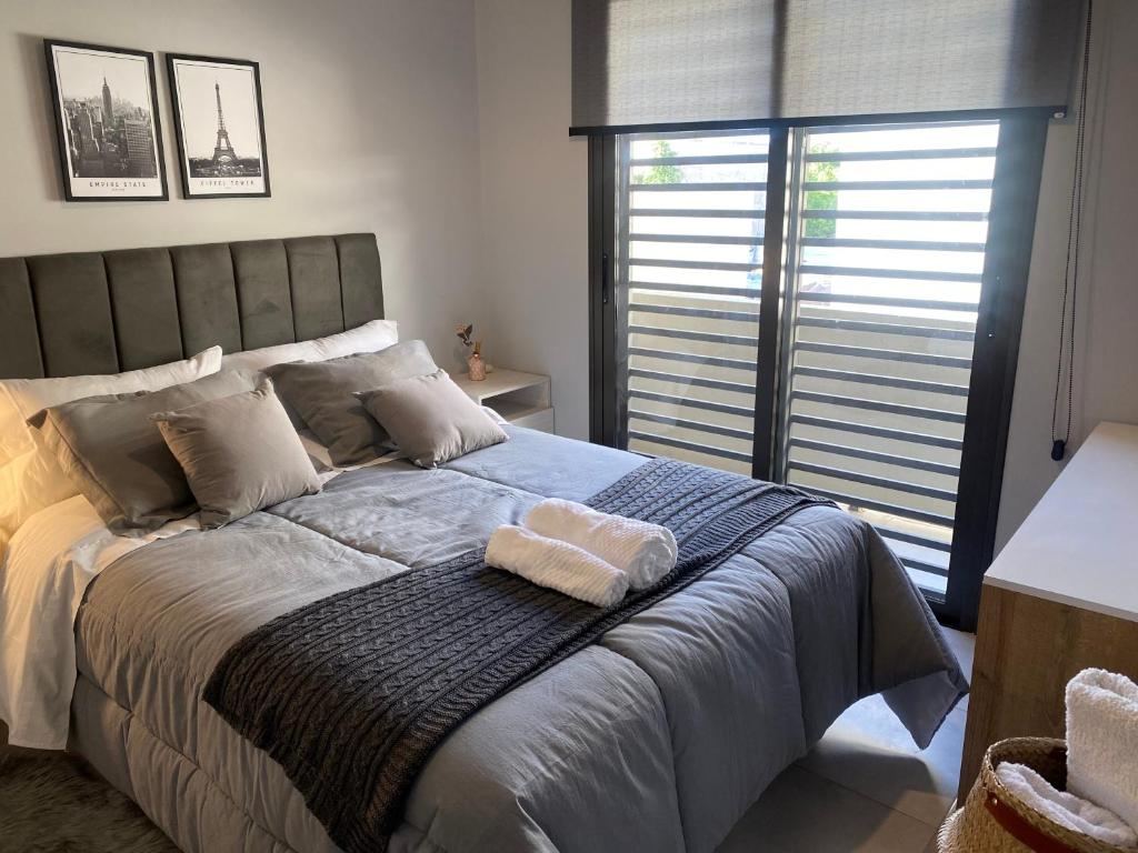 a bedroom with a large bed with two towels on it at Micro ensueño in Godoy Cruz