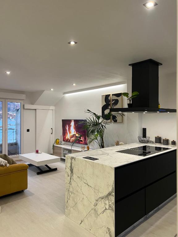 a kitchen with a counter and a living room with a fireplace at Ático playa Palmás in Moaña