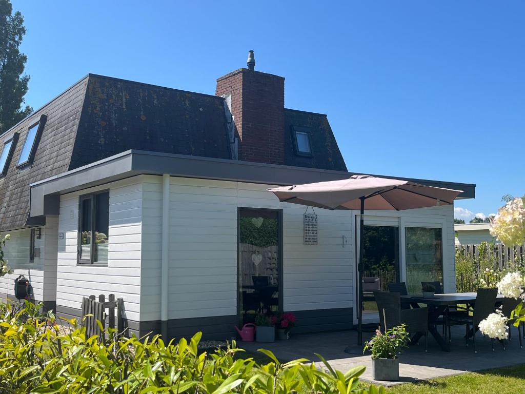a house with a table and an umbrella at Piratennest Breskens in Breskens