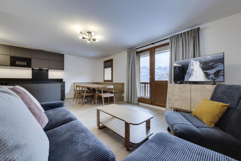 un salon avec un canapé et une table dans l'établissement Résidence Maison Neuve - Appartement rénové·Pied des pistes·Balcon·Parking MAE-0391, à Tignes