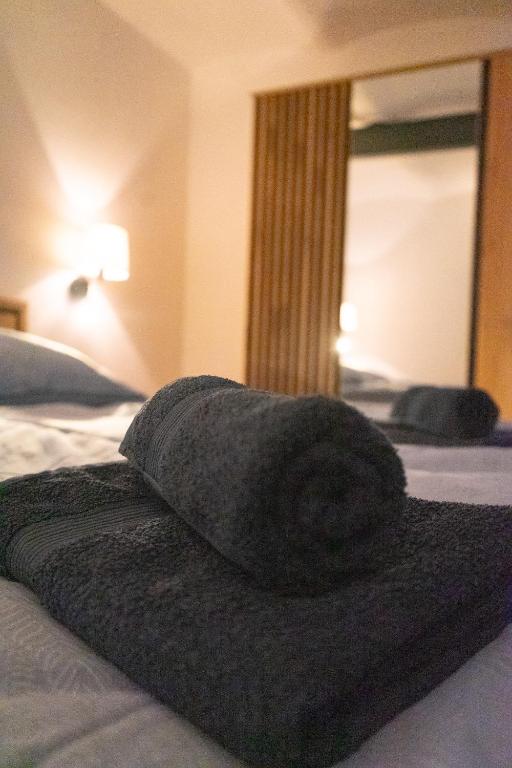 a black towel laying on a bed in a bedroom at Ferienwohnung "Wasser" mit Sauna im Ferienhaus am Waldbach in Kirchzell