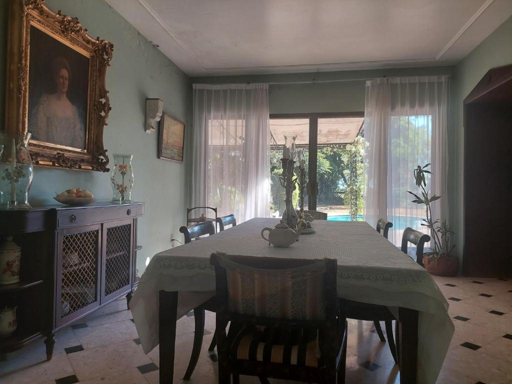 una sala da pranzo con tavolo, sedie e finestra di Residencia Casa del Roble 1 a Cuernavaca