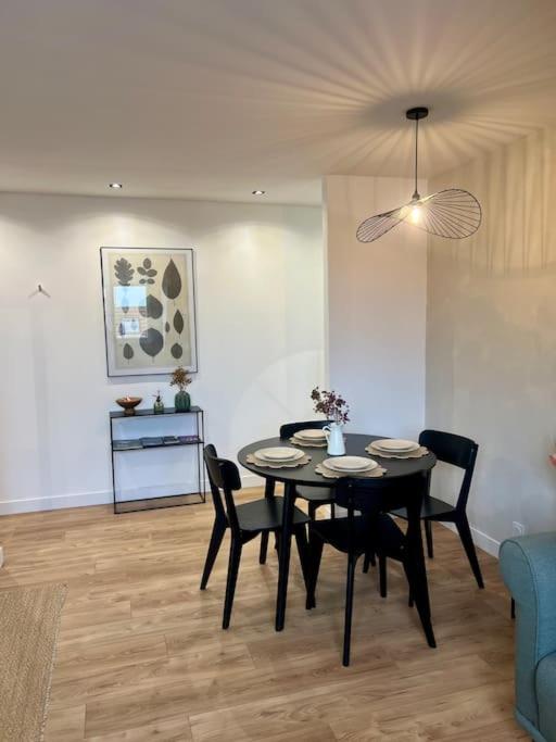 une salle à manger avec une table, des chaises et un canapé dans l'établissement L Émeraude, à Beauvais