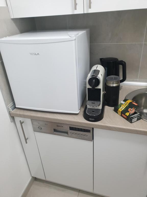 a kitchen counter with a white refrigerator next to a sink at Natalija Stan na dan in Banja Luka