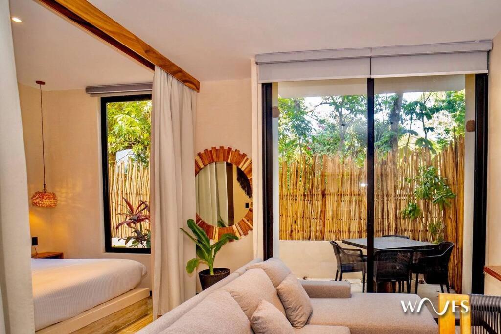 a bedroom with a bed and a couch and a mirror at Natural Lighted Boho Chic Studio with Private Pool by Waves in Tulum