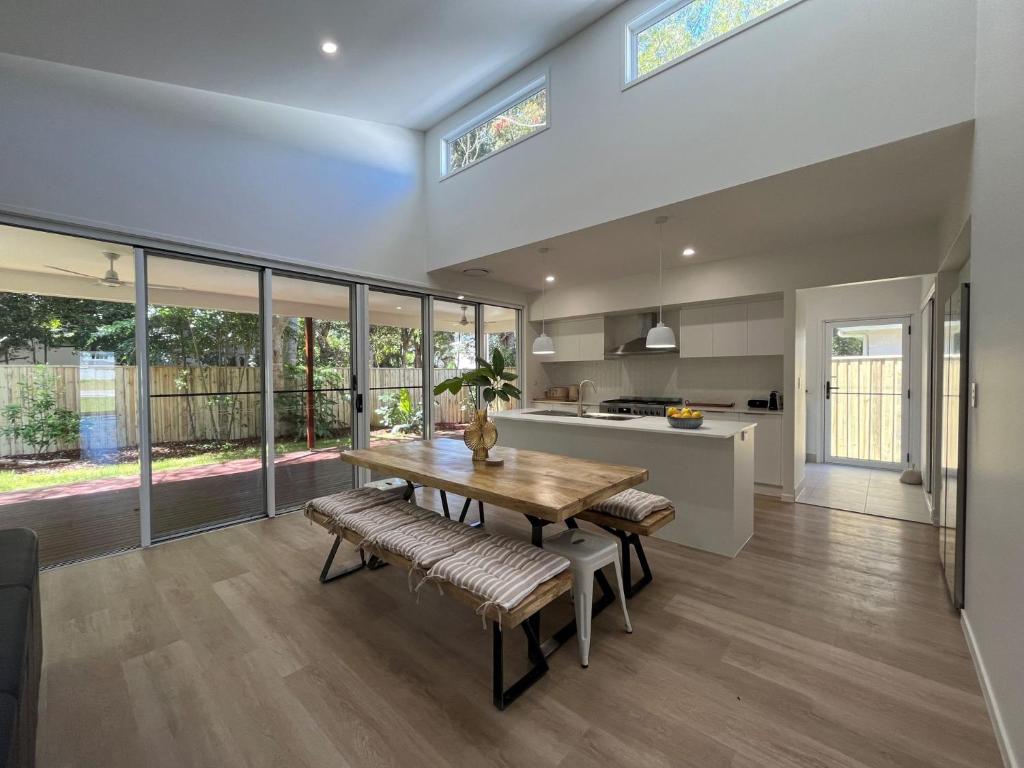 a kitchen and dining room with a wooden table and chairs at 6 Yeri Drive - Rainbow Shores. Aircon. Pets Welcome. Walk to beach in Rainbow Beach