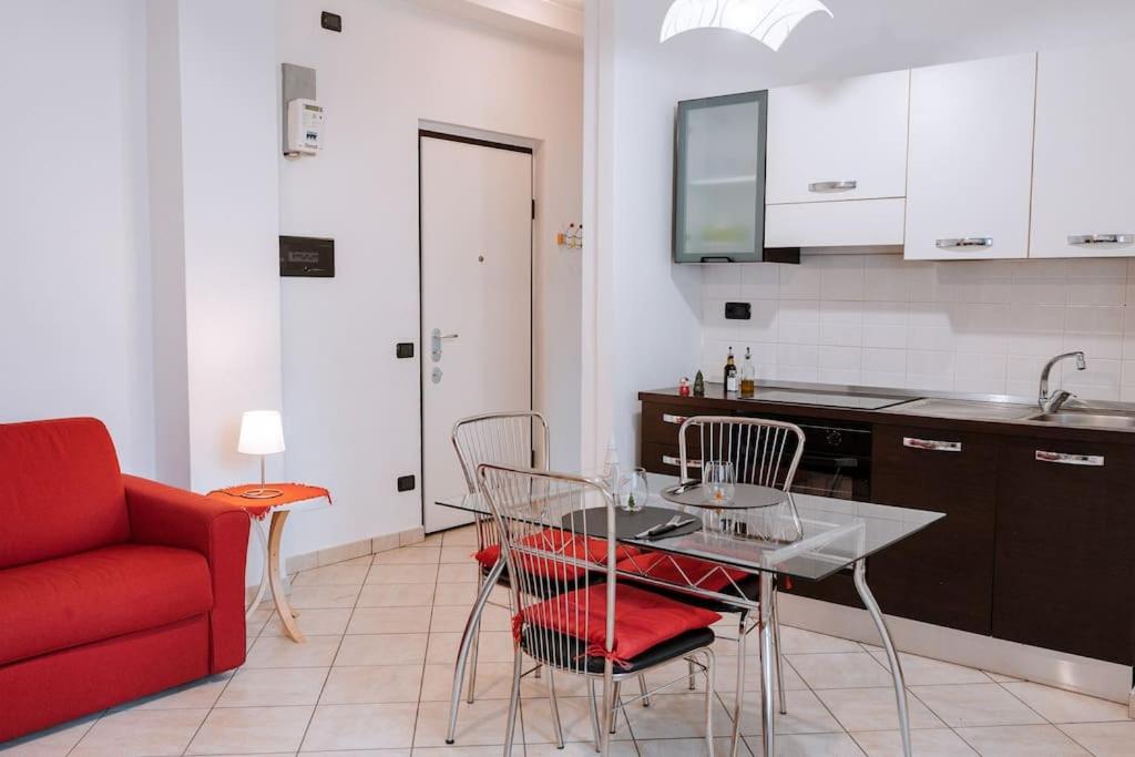 una cucina con tavolo, sedie e divano rosso di La Petite Vue ad Aosta
