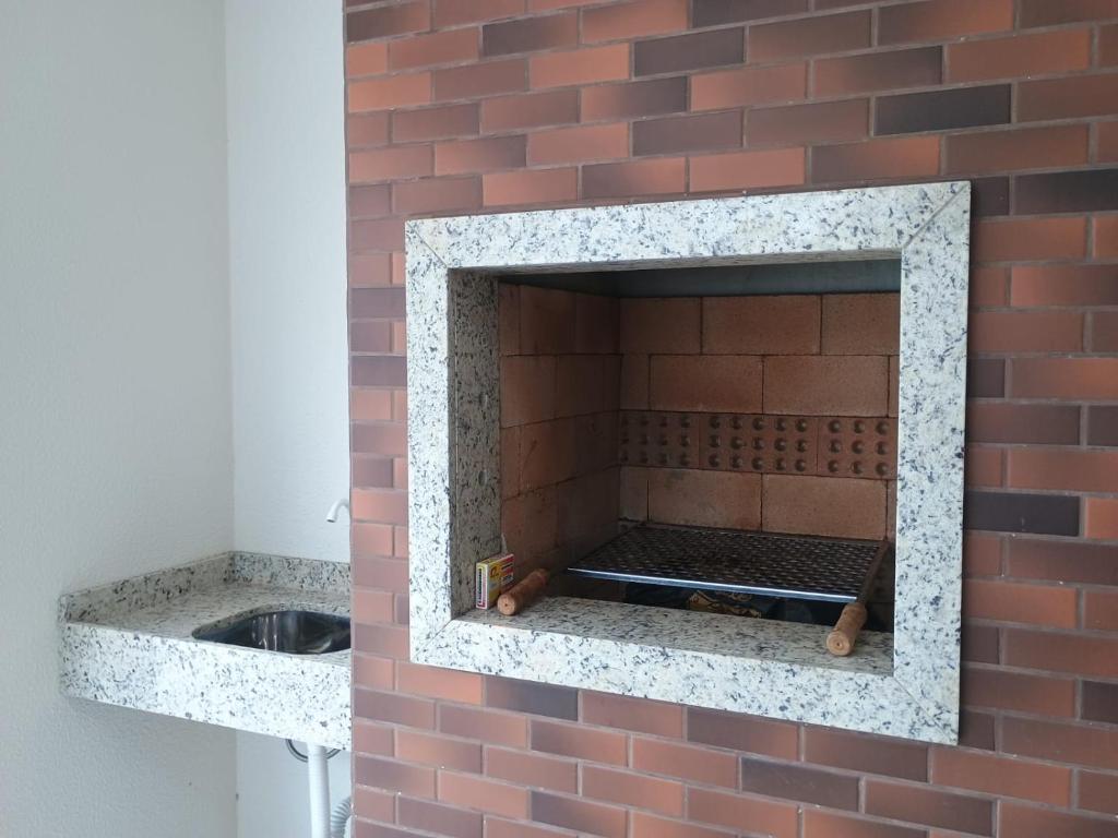 a brick fireplace in a brick wall with a sink at Recanto Aguapés in Governador Celso Ramos
