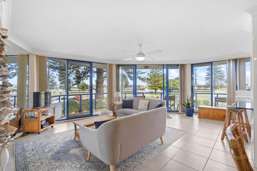 a living room with a lot of windows at Heritage 102 in Tuncurry
