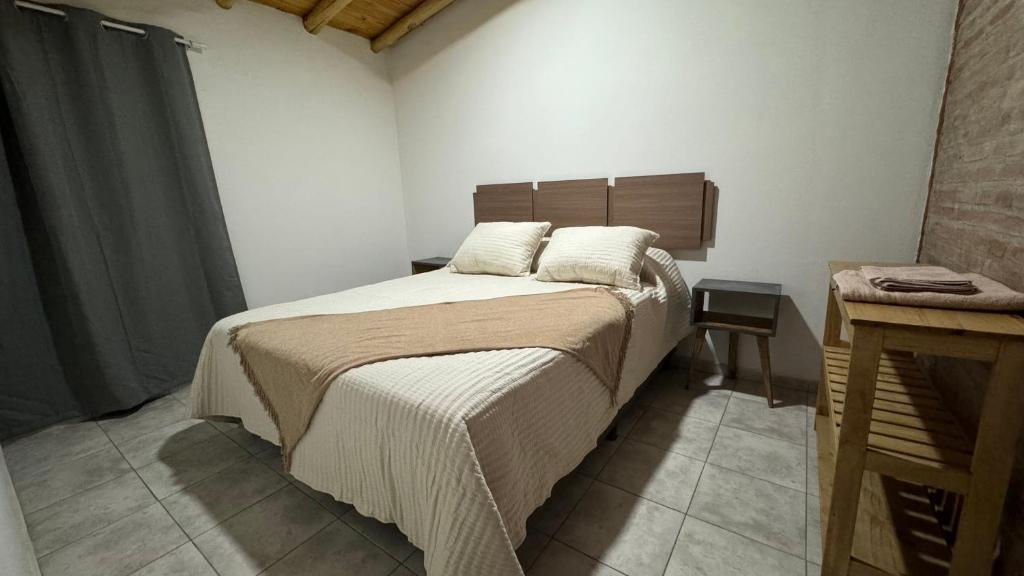 a bedroom with a bed and a wooden headboard at Alquiler Centro SAN RAFAEL in San Rafael