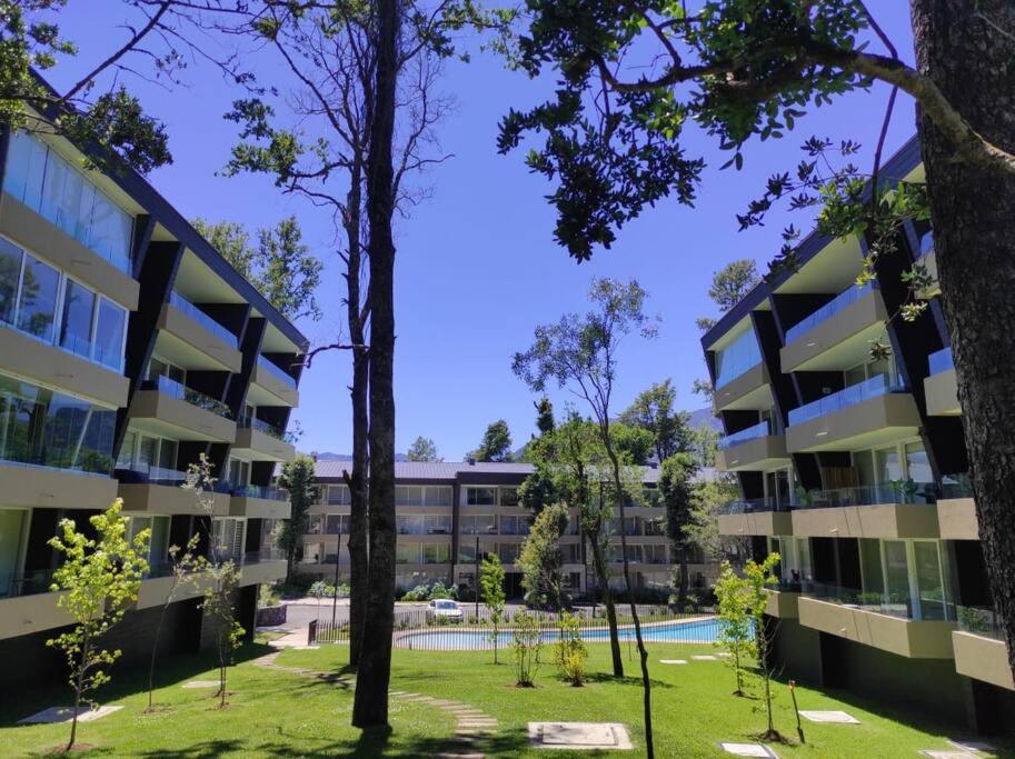 an image of an apartment building with trees in the foreground at Alta Vista Pucon Centro II in Pucón