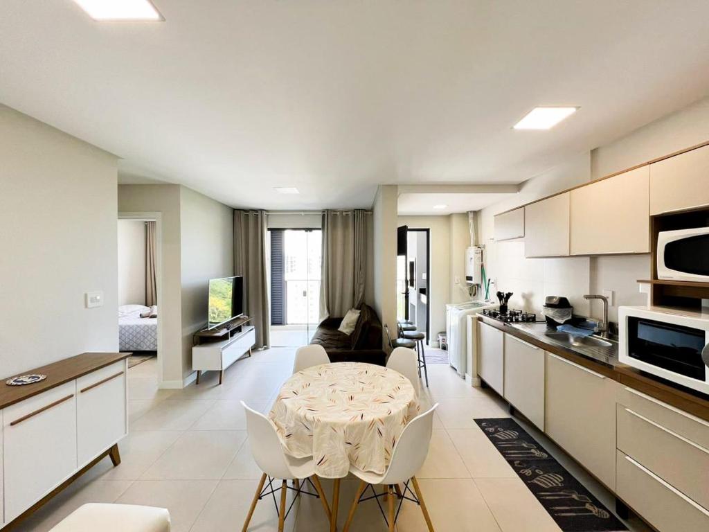 Una cocina y una sala de estar con mesa y sillas. en AP Excelente 10 andar Praia Brava Vista ao horizonte, en Itajaí