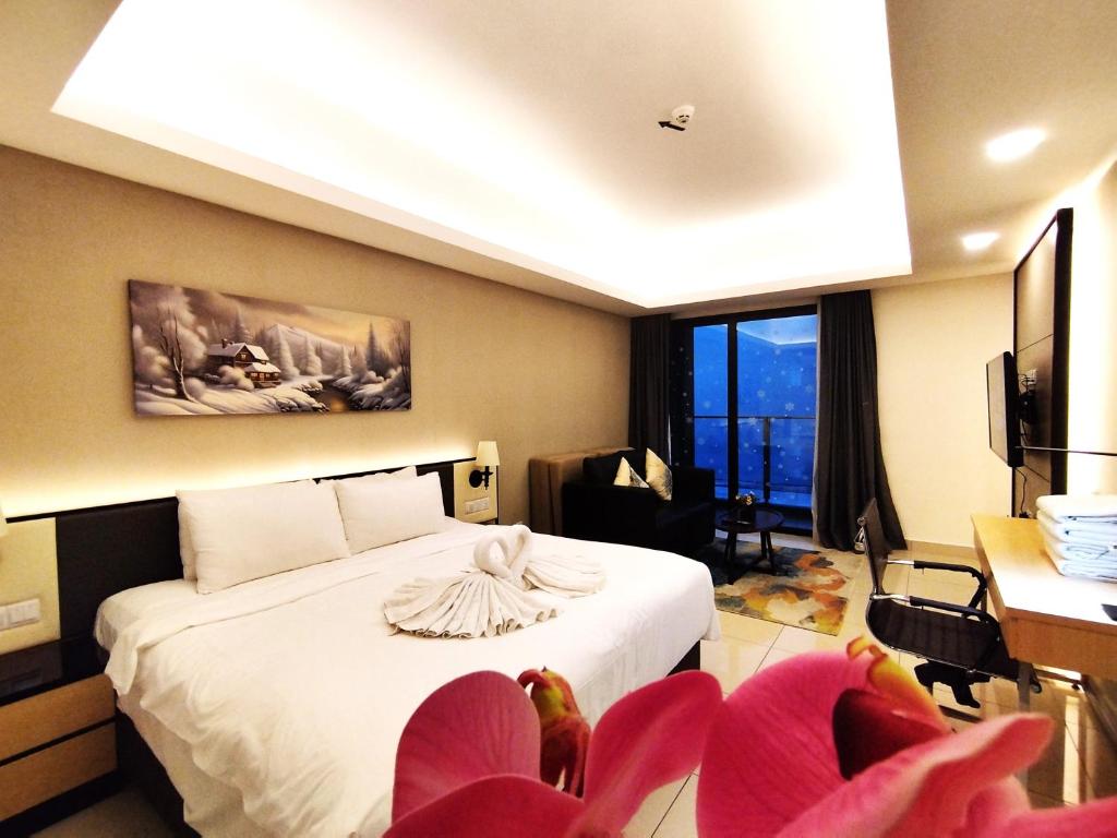 a hotel room with a bed and some pink chairs at Genting EscapeColdStudio AT Ion Delemen in Genting Highlands