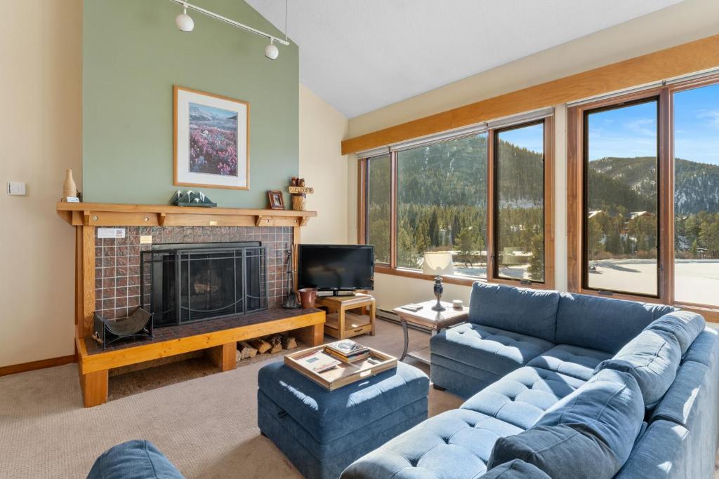 a living room with a blue couch and a fireplace at Lenawee 1740 by Summit County Mountain Retreats in Keystone