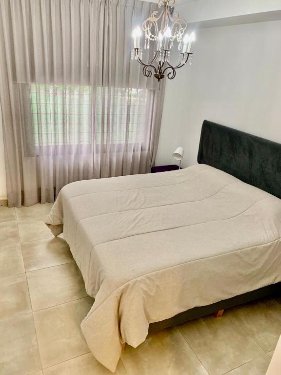 a bedroom with a large bed and a chandelier at Allende Apart St in Villa Allende