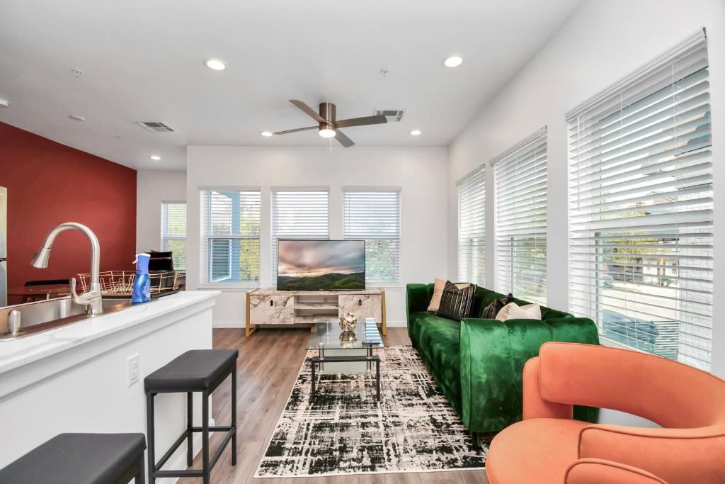 un soggiorno con un divano verde e una cucina di Serenity Studios - Near Med Center & Museum District a Houston