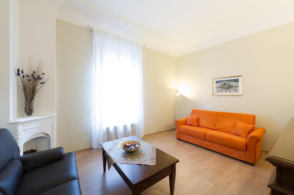 フィレンツェにあるカルツァイオーリ アパートメントのリビングルーム(オレンジカウチ、コーヒーテーブル付)