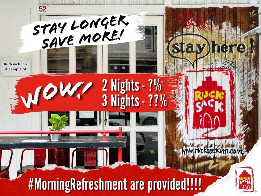 a bunch of signs on the side of a building at Rucksack Inn Temple Street in Singapore