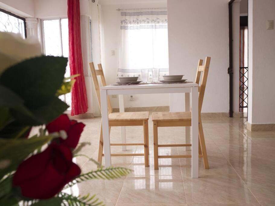 a white table and chairs in a living room at Encantador Apartamento con agua caliente in Los Paredones