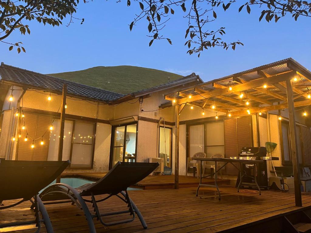 a deck with a table and chairs and lights at ネバーランド伊豆 Neverland IZU in Ito
