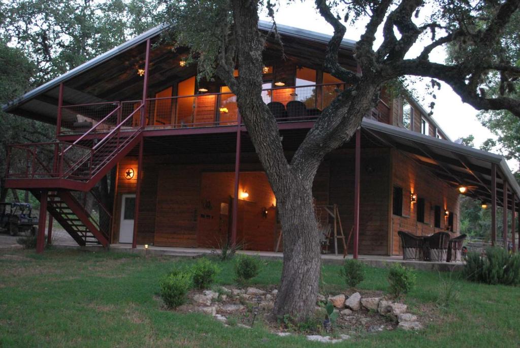 a large house with a tree in front of it at Rockin' B Ranch Creek View Barndominium in Pipe Creek