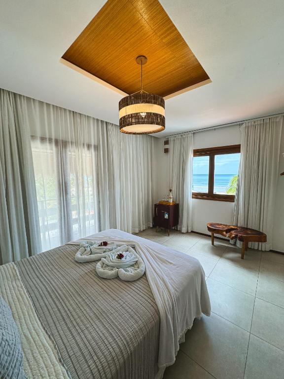 a bedroom with a bed with two towels on it at Junduh Brasil Pousada e Restaurante in Icaraí