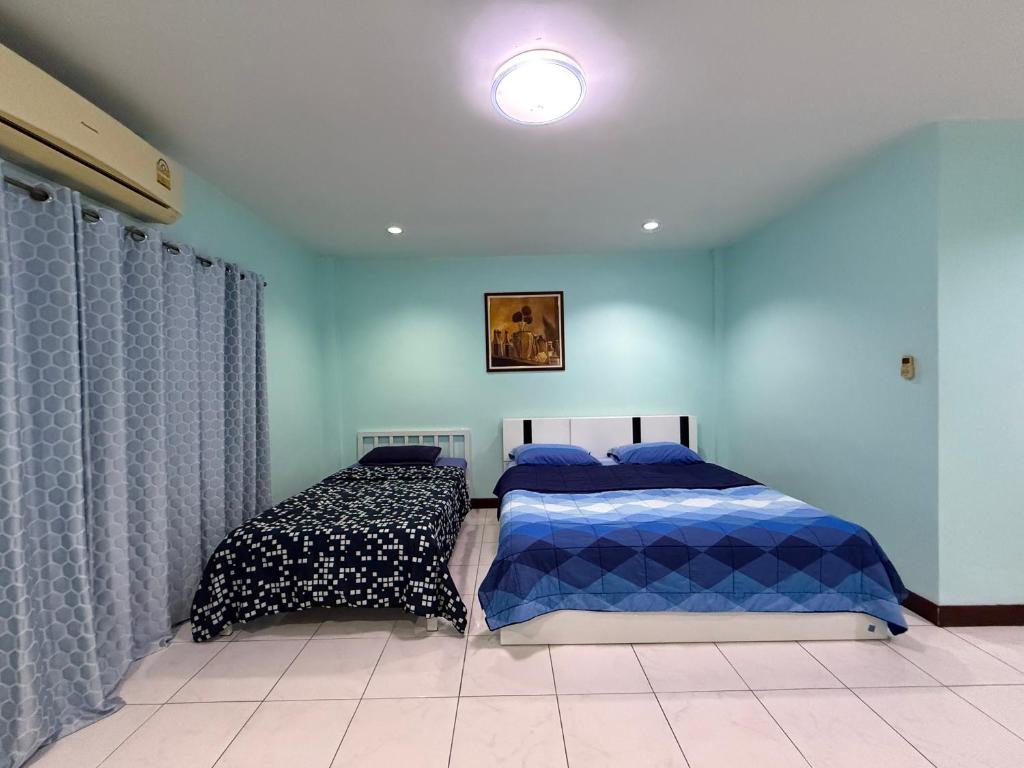 a bedroom with two beds with blue walls at Best Rent a Room in Nai Yang Beach