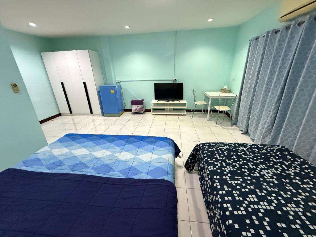 a room with two beds and a tv in it at Best Rent a Room in Nai Yang Beach