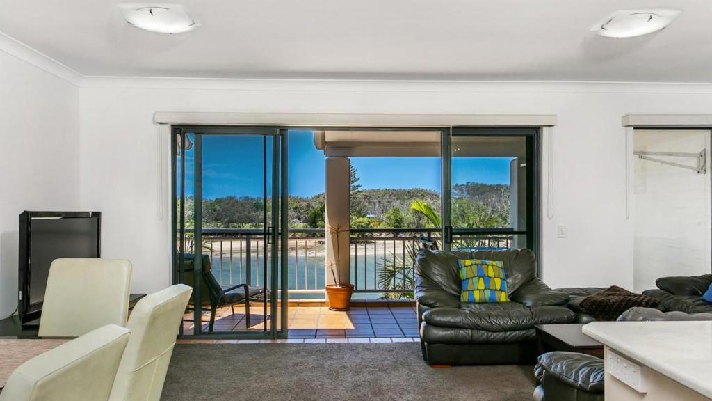 a living room with a couch and a table at Sunrise Cove Holiday Apartments by Kingscliff Accommodation in Kingscliff