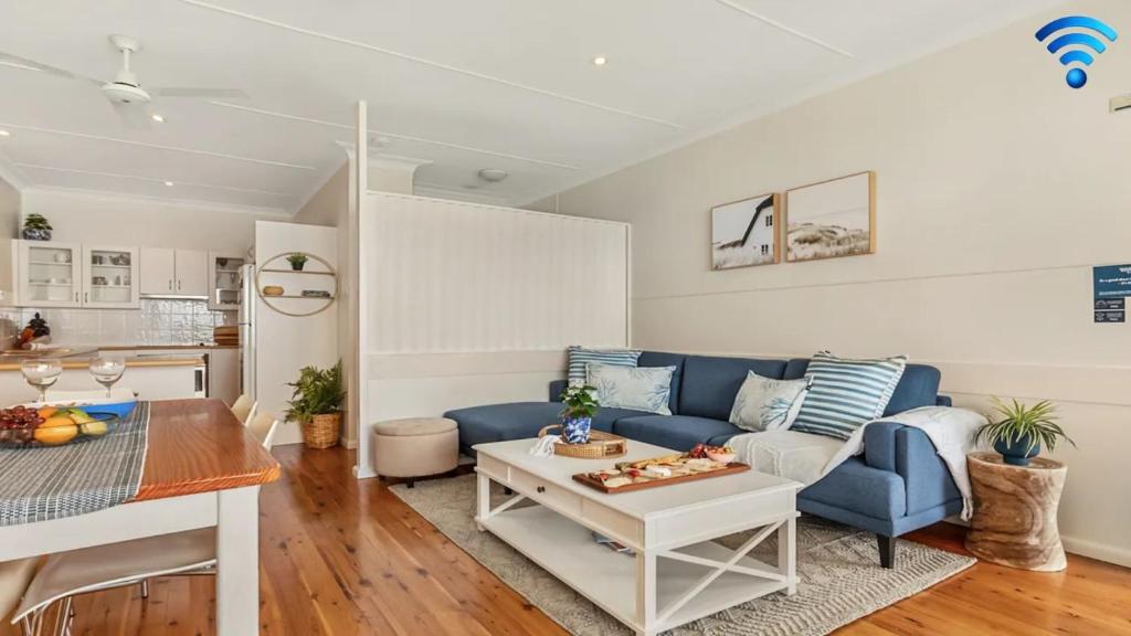 a living room with a blue couch and a table at Ocean Blue Apartment Two in Currarong