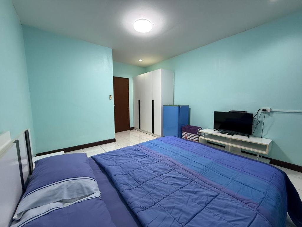 a bedroom with a large bed and a tv at Best Rent a Room in Nai Yang Beach