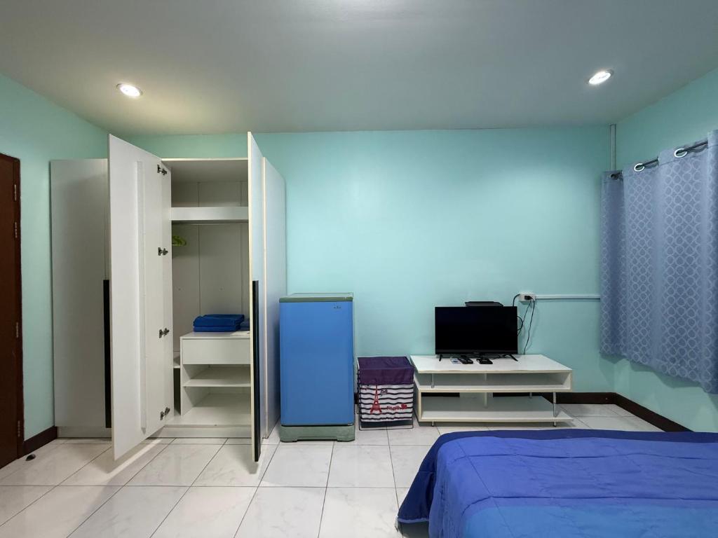 a bedroom with a bed and a blue wall at Best Rent a Room in Nai Yang Beach