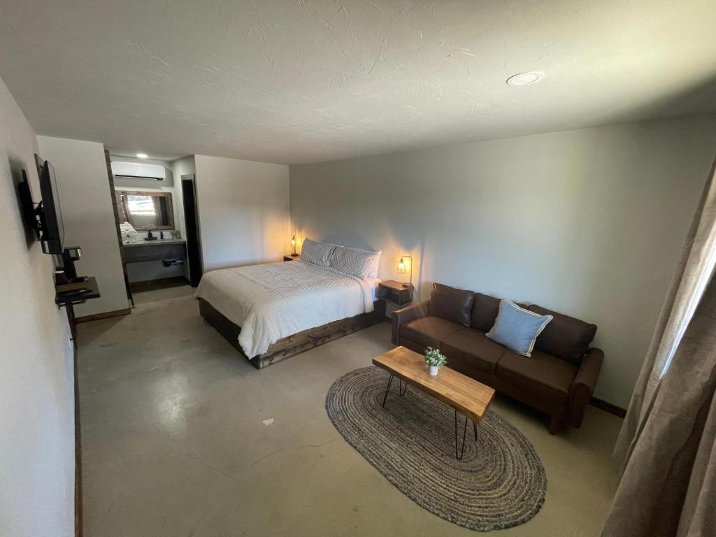 a bedroom with a bed and a couch and a table at The Rocky Retreat in Cookson